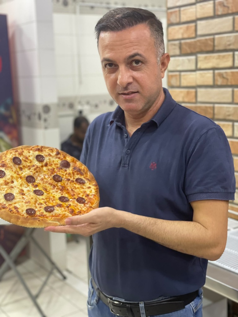Alasali Master Baker presenting fresh handcrafted pizza in Riffa